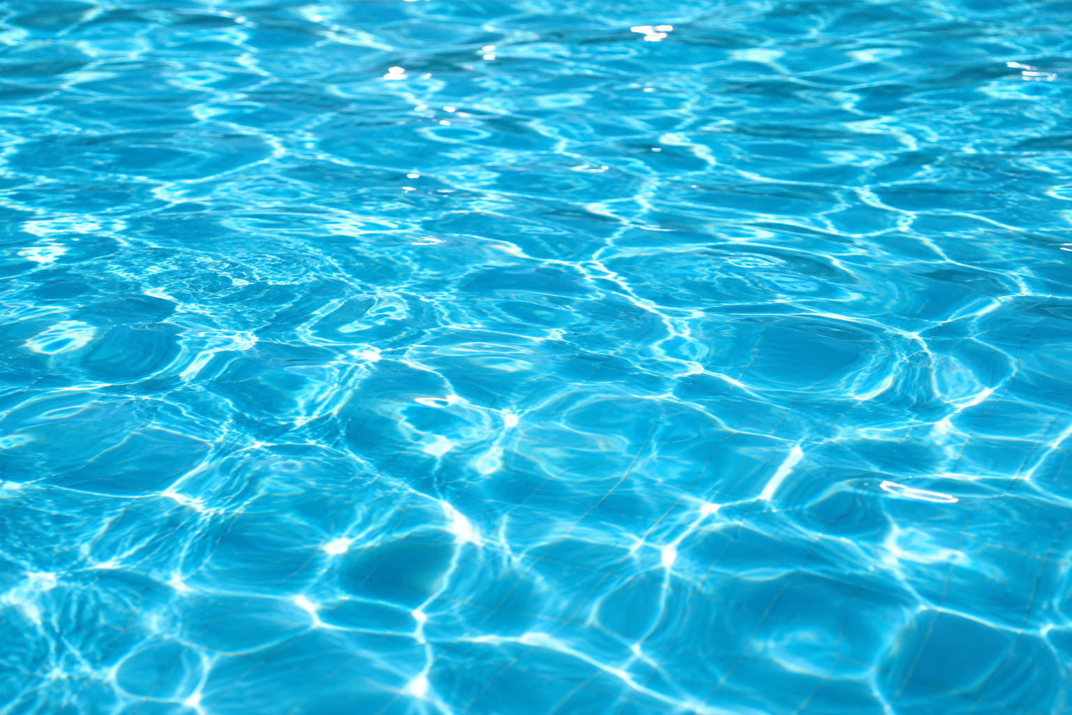 Surface d'eau de piscine turquoise éclairée par le soleil