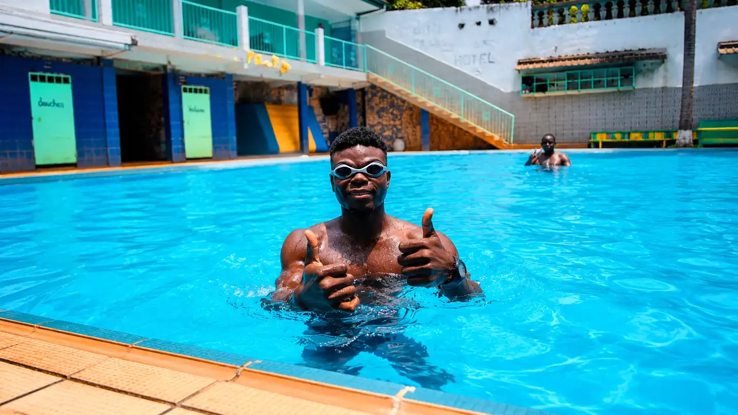Élève souriant profitant d'une séance de natation relaxante au Cameroun.